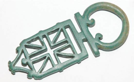 Ce magnifique modèle de clé à platine a été trouvé en foret avec un détecteur de métaux il y a quelques années. On vous l’avait d’ailleurs déjà présenté dans ces pages. Le pertuis est de forme complexe, la patine fa buleuse, l’anneau peltoide complet. Cette clé mesure en outre 10 cm ! Une pelta est petit bouclier léger en forme de croissant lunaire, avec une ou deux échancrures demi-circulaires. Ce motif est typique de l’an tiquité et se retrouve sur de nombreux artefacts tels les appliques, pendants, fibules etc...