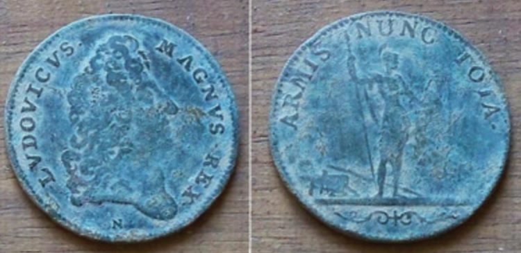 Il existe un très grand nombre de jetons frappés sous Louis XIV ; celui-ci, trouvé par Franckomas34, indique au revers la légende « ARMIS NUNC TOTA », qui signifie « Maintenant tout par les armes » ; est-ce un aveu pour ce roi qui proclama sur son lit de mort « J’ai trop aimé la guerre »… ou peut-être un rappel de la force de l’armée française qui, à cette époque, avec 300 000 hommes, est la plus puissante d’Europe.